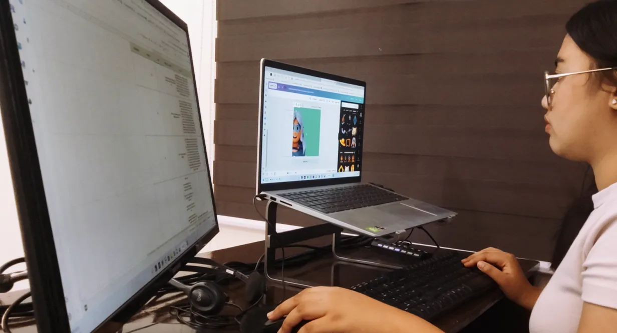 Woman working on a computer in front of two monitors image